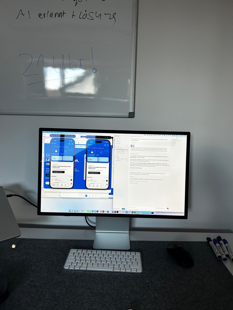 Studio Display mit zwei Entwürfen der Scooly-App, daneben ein Whiteboard mit Notizen